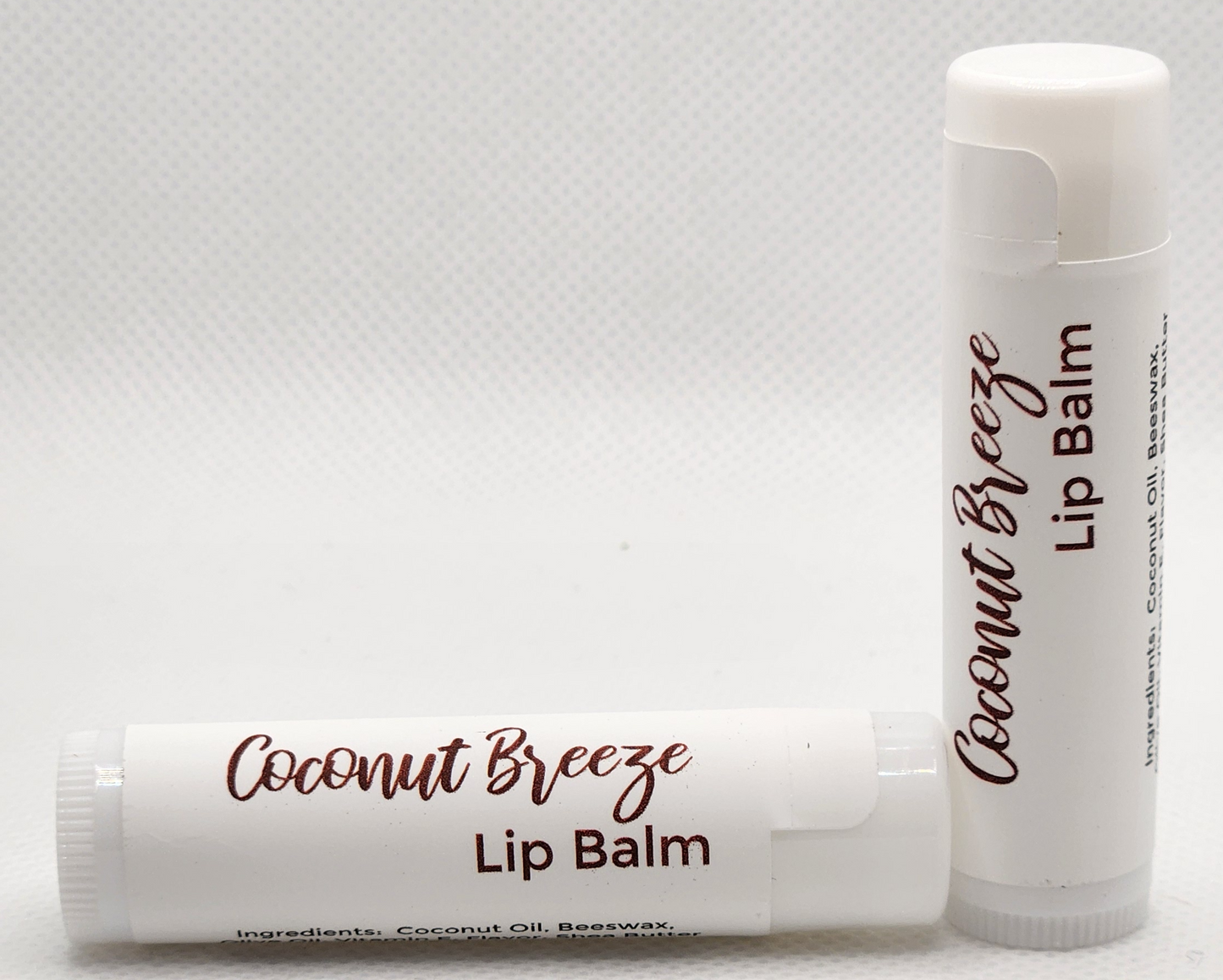 A sleek, eco-friendly tube of Coconut Breeze lip balm, with a minimalist design and clear labeling. The tube is a light, natural color with the product name displayed in elegant, clean fonts.