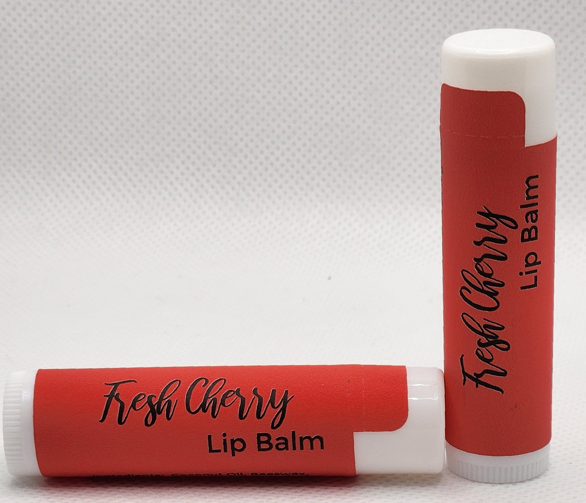 A sleek, eco-friendly tube of Fresh Cherry lip balm, with a minimalist design and clear labeling. The tube is a red with the product name displayed in elegant, clean fonts.