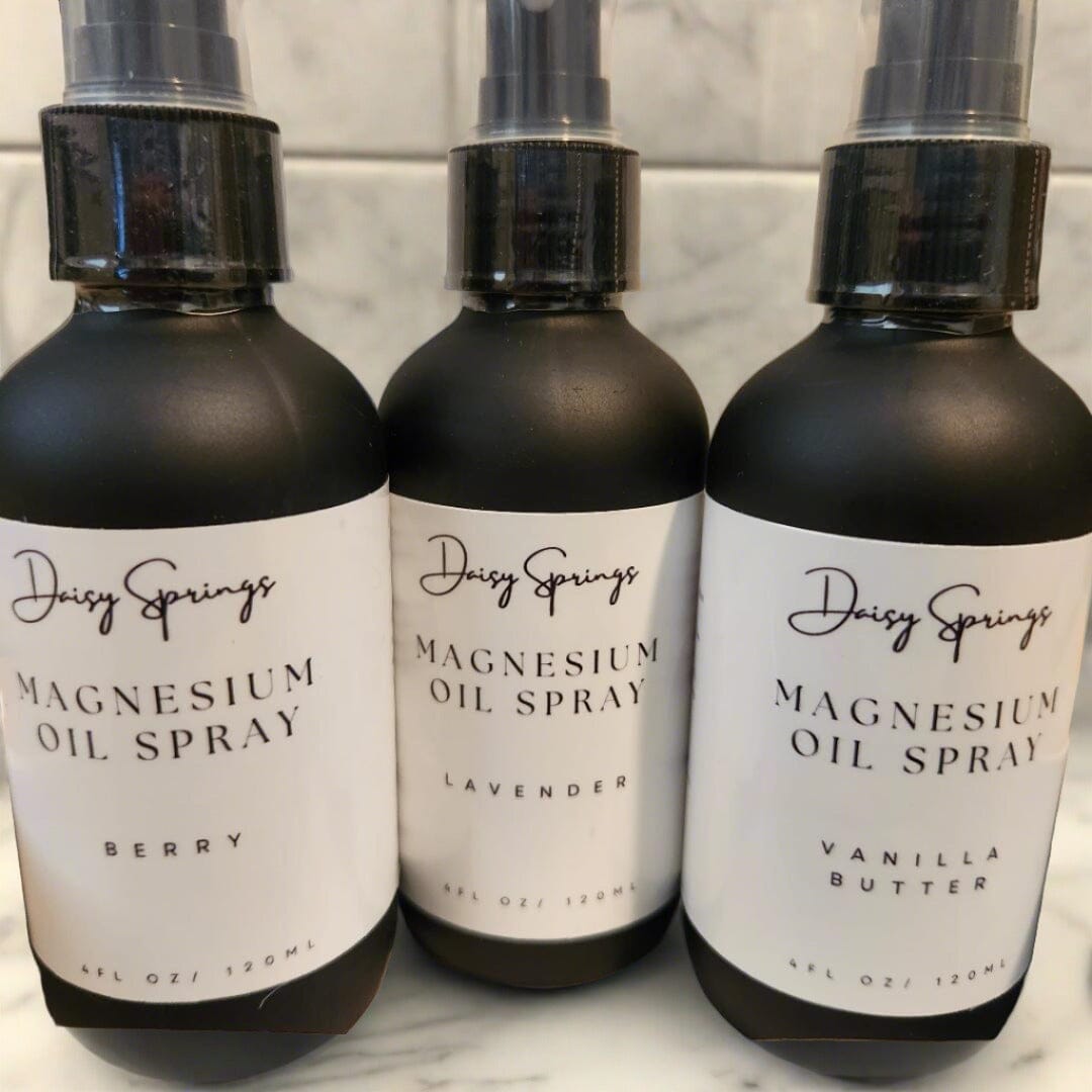 Showcasing 4 oz magnesium sprays in back frosted glass bottles with white Daisy Springs product label. Use for better sleep.